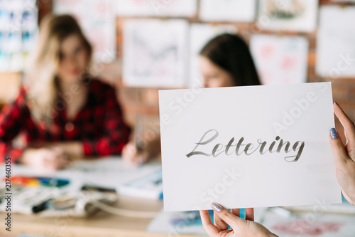 lettering art and calligraphy craft. italic cursive handwriting courses. woman hands holding paper with text. creative leisure and artistic hobby.