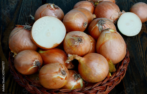 A lot of yellow onions in basket. Yellow onions are the most popular cooking onions because they add excellent flavor to most stew, soups, and meat dishes.