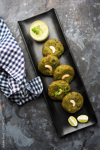 Hara bhara Kabab or Kebab is Indian vegetarian snack recipe served with green mint chutney over moody background. selective focus photo