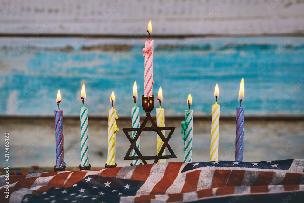 Burning hanukkah candles in a menorah on colorful candles from a menorah