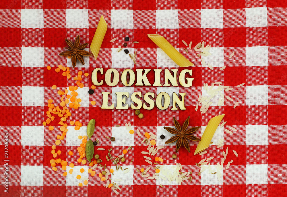 Fototapeta premium Cooking lesson written with wooden letters on checkered cloth and cooking ingredients 