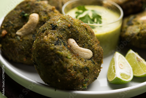 Hara bhara Kabab or Kebab is Indian vegetarian snack recipe served with green mint chutney over moody background. selective focus photo