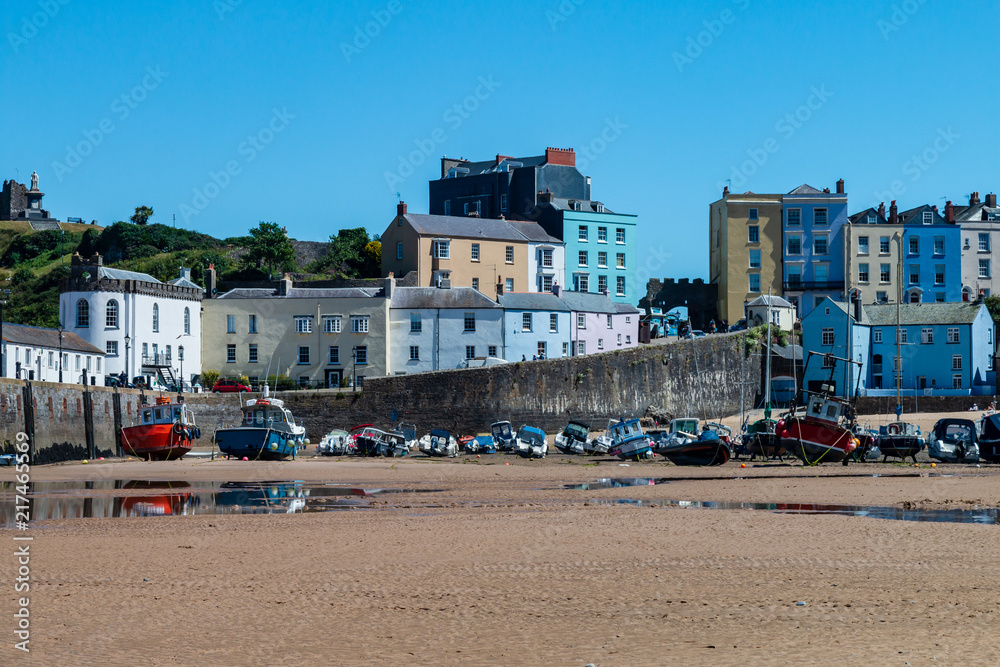 Colorful boats aground on the sand at Tenby Harbour at low tide