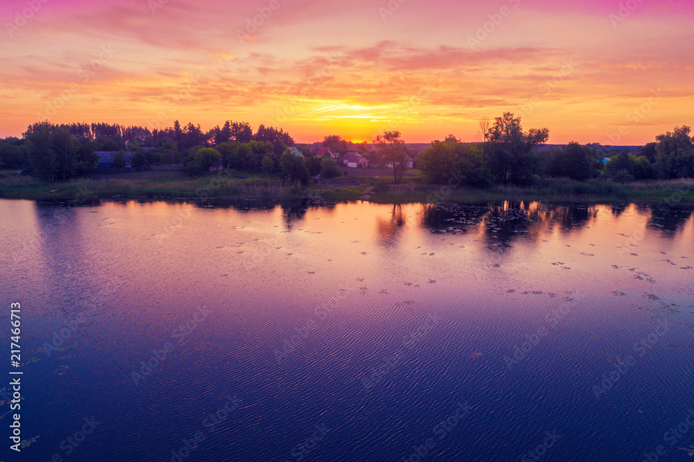 View of countryside and lake in evening.