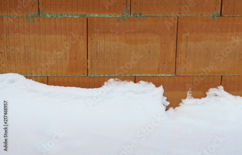Mauerwerkswand mit Schnee auf Rohbau Baustelle im Winter