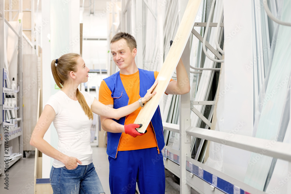 salesman in construction store offers goods to a woman client salesman in construction store offers goods to a woman client