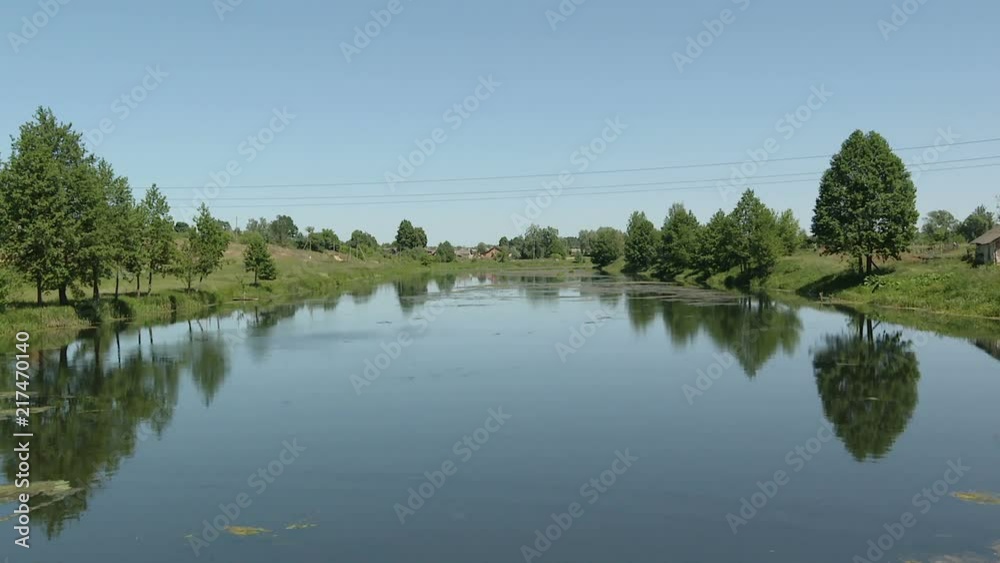 Recording to the camera, the landscape from the center of the river. A small rural small river in a summer sunny day. Quiet sunny day. Recording to the camera, the landscape from the center of the river. A small rural small river in a summer sunny day. Quiet sunny day.