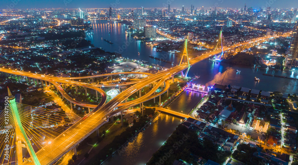 Fototapeta premium Aerial view network or intersection of highway road and cityscape background for transportation or distribution concept.