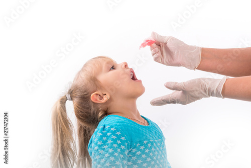little girl on reception at the doctor receives the polio vaccine, a child being treated for influenza, the child takes the medicine in the hospitalception at the doctor takes antipyretic, 