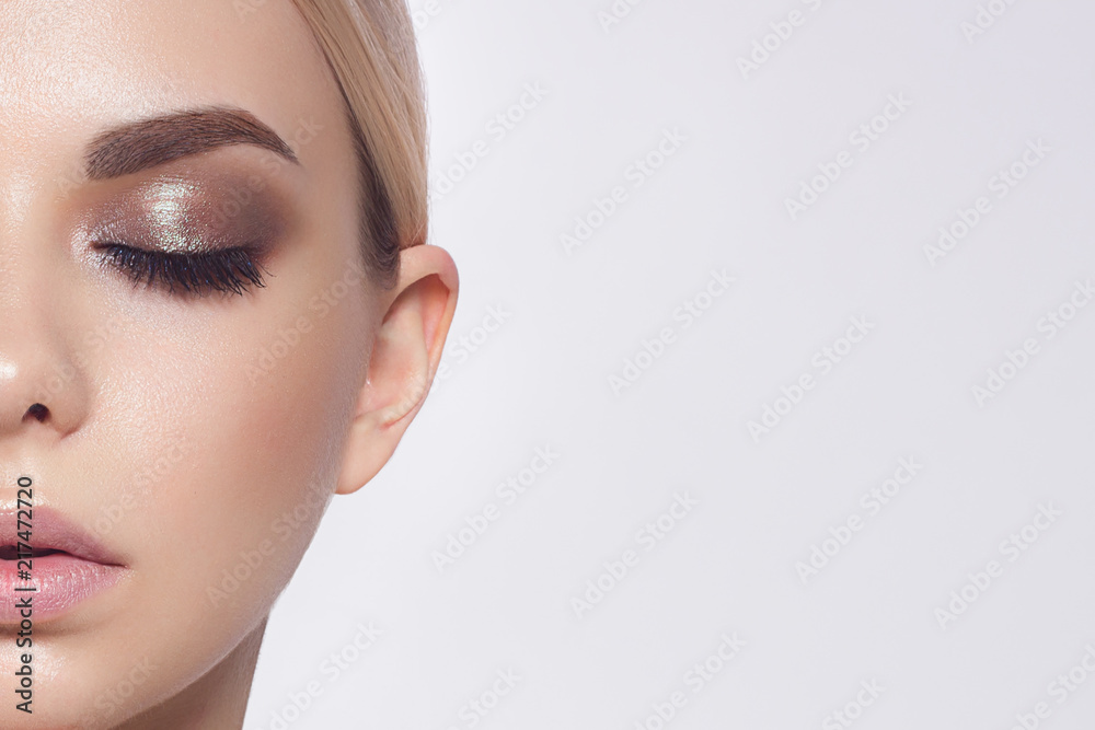 Fototapeta premium Szczelnie usta kobiety makijaż moda naturalny beżowy szminka. Makro seksowny makijaż blady błyszczyk. Delikatna czysta skóra i faliste blond włosy. Kosmetologia, Spa, wzrost warg