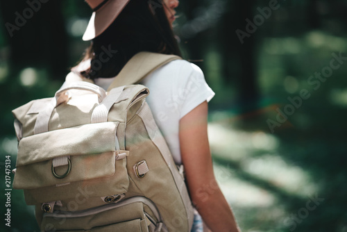 Handsome young traveler girl hold location map in hands and looking directional way for traveling with backpack
