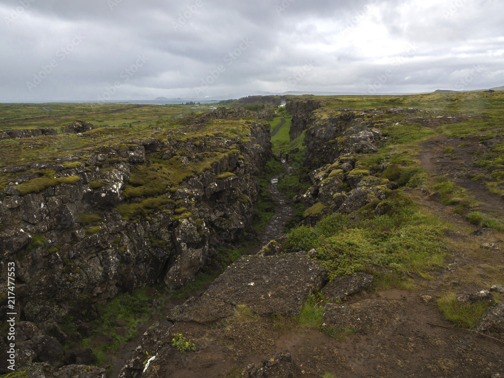 View on north american - europe lithosferic rift - Mid-Atlantic Ridge in Thingvellir national park, Iceland with foot path and walking tourist people