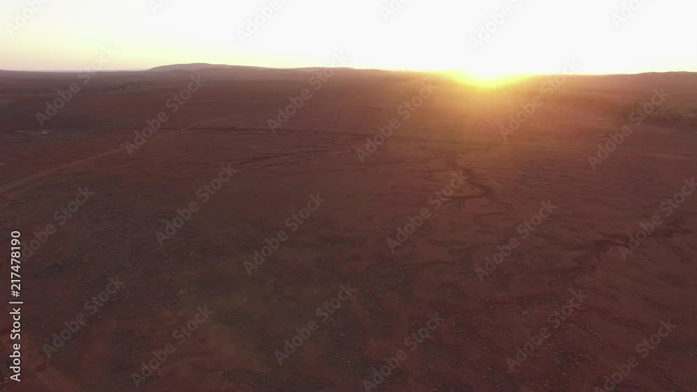 Slow rise over red dry cracked land into the sun at sunset Slow rise over red dry cracked land into the sun at sunset