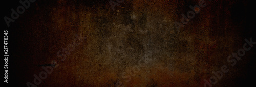 Textur einer fast schwarzen, rostfarbenen und alten Betonwand, auf die leichtes Licht fällt in XXXL als moderner Hintergrund photo