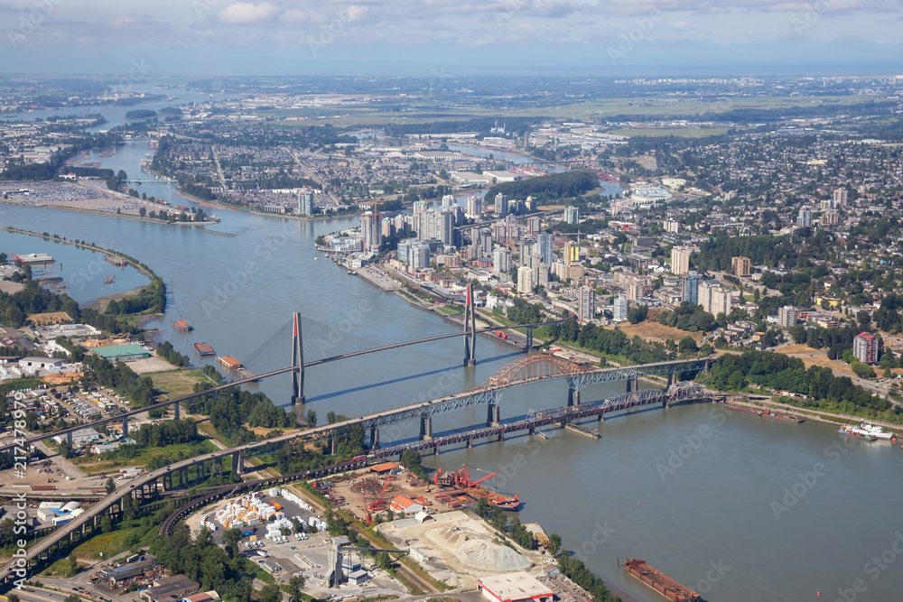 Obraz premium Aerial city view of Pattullo and Skytrain Bridge across the Fraser River. Taken in Greater Vancouver, British Columbia, Canada.