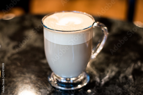 Milky Latte In Glass Mug On Dark Table At Diner