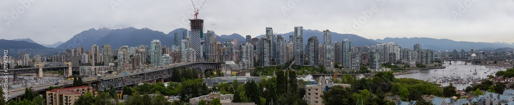 Aerial panoramic view of Downtown City during a cloudy summer evening before sunset. Taken in Vancouver, British Columbia, Canada.