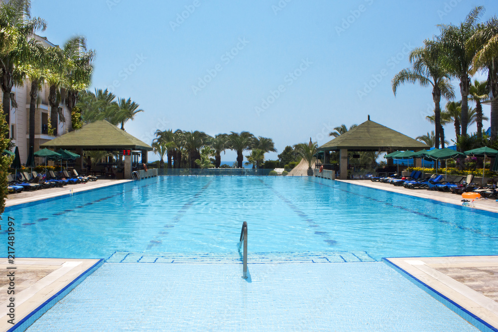 View of the Mediterranean Sea, blue pool and palms View of the Mediterranean Sea, blue pool and palms