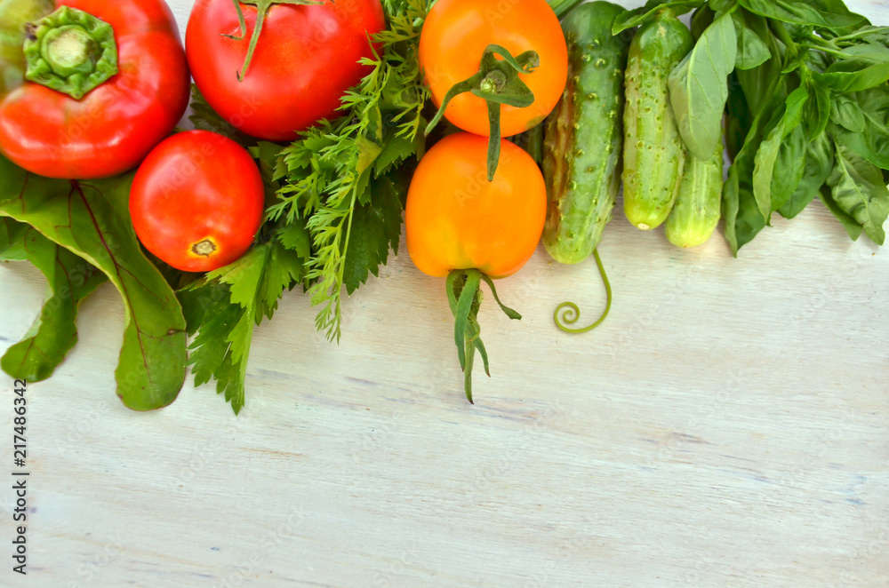 fresh tomatoes and peppers, cucumbers and celery and Basil on wooden 