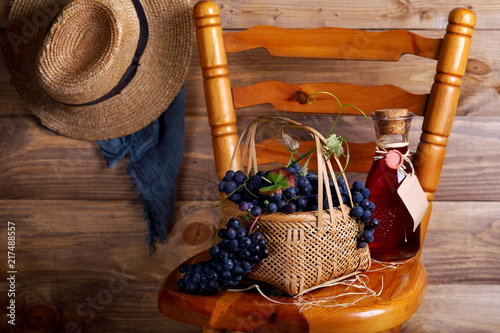 виноград в корзине на стуле с бутылкой вина