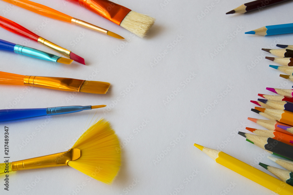 Abstract background from paintbrushes and color pencils on white Abstract background from paintbrushes and color pencils on white
