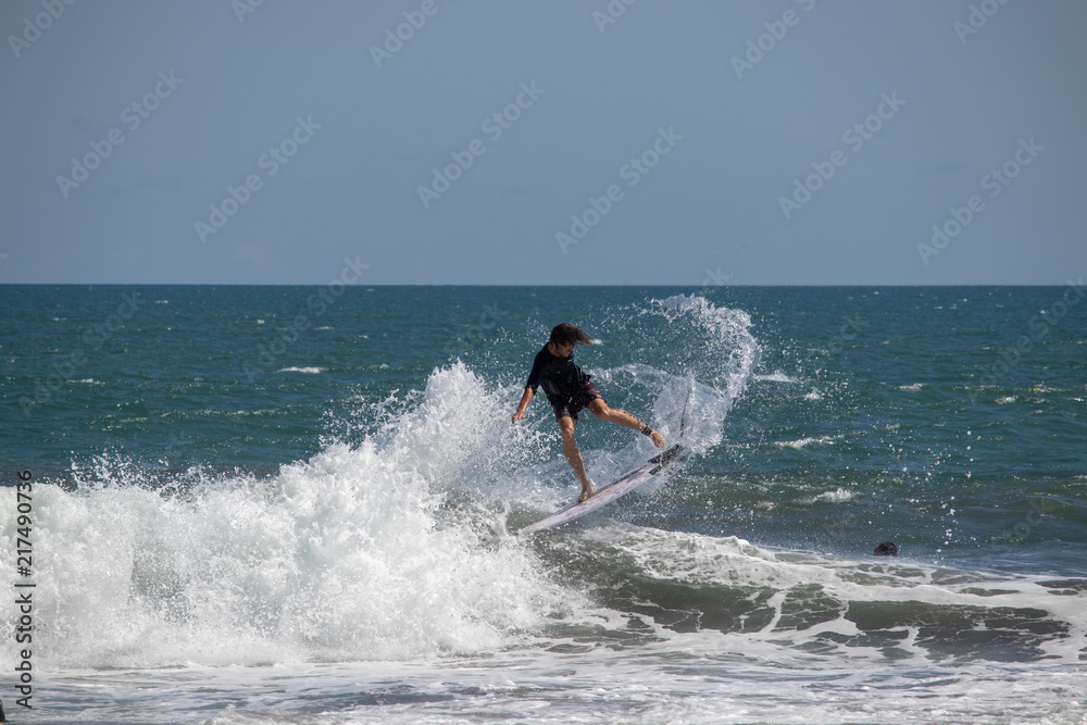 Surfer riding wave at Echo Beach Canggu Bali Indonesia Surfer riding wave at Echo Beach Canggu Bali Indonesia