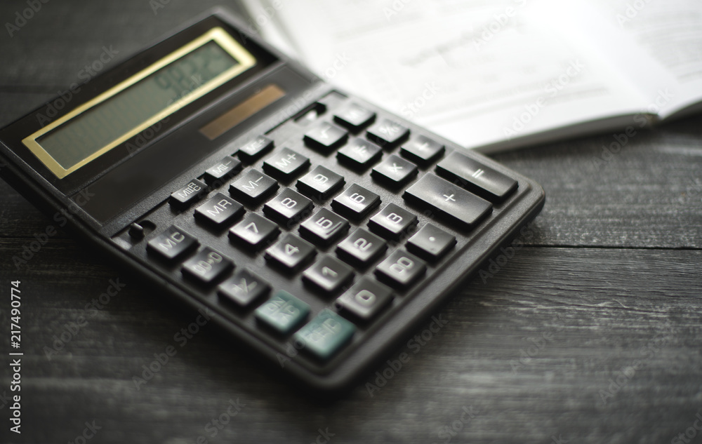 horizontal background with a calculator on a dark wooden surface of the table horizontal background with a calculator on a dark wooden surface of the table