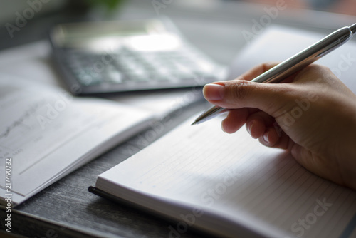 a person n holding metallic pen over the white sheet  for writing