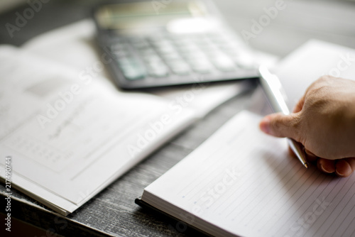 a person puts a metal pen on a notebook