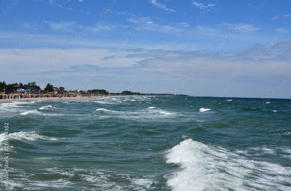 Menschen baden in der Ostsee bei hohen Wellen