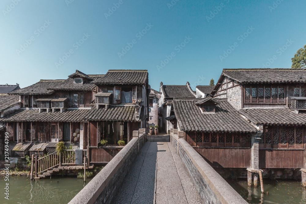 Fototapeta premium Stone Bridge Leading to Chinese Houses