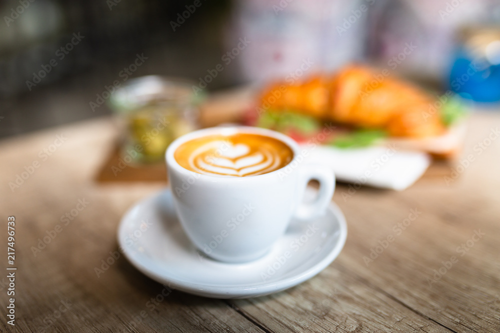 Coffee and croissant sandwich at table in snack bar. Coffee and croissant sandwich at table in snack bar.