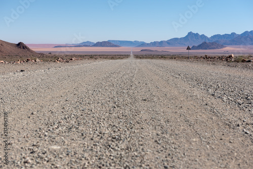 Low view angle of open gravel road to horizon in desert, Namibia