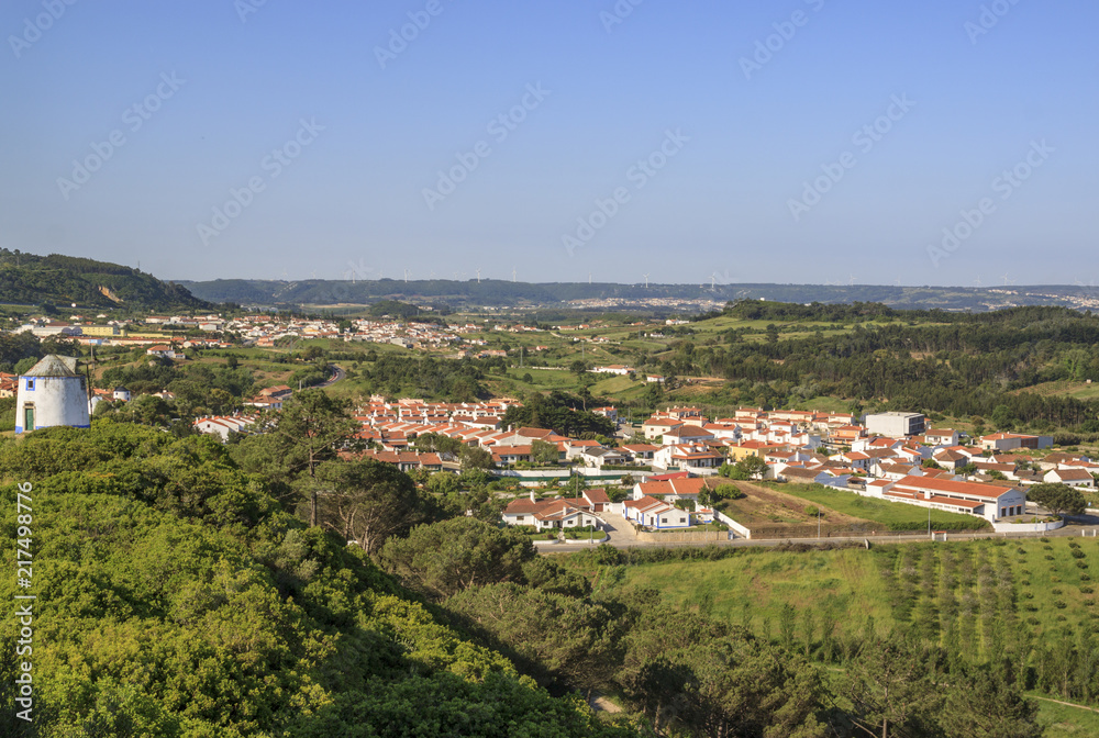 Scenic view of the valley from wall of fortress. White houses red tiled roofs Beautiful old town with medieval. Obidos village, Portugal. Summer sunny day.