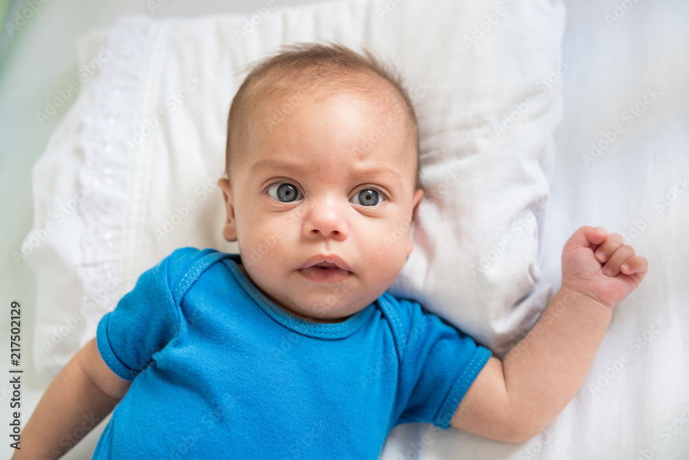 Blue eyed baby boy lying in crib - Lifestyle Blue eyed baby boy lying in crib - Lifestyle