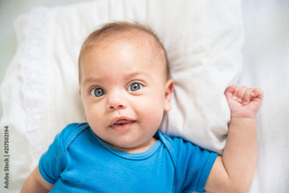 Blue eyed baby boy lying in crib - Lifestyle