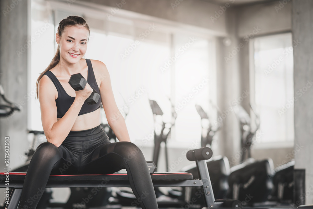 Caucasian woman using dumbbell to exercise Caucasian woman using dumbbell to exercise