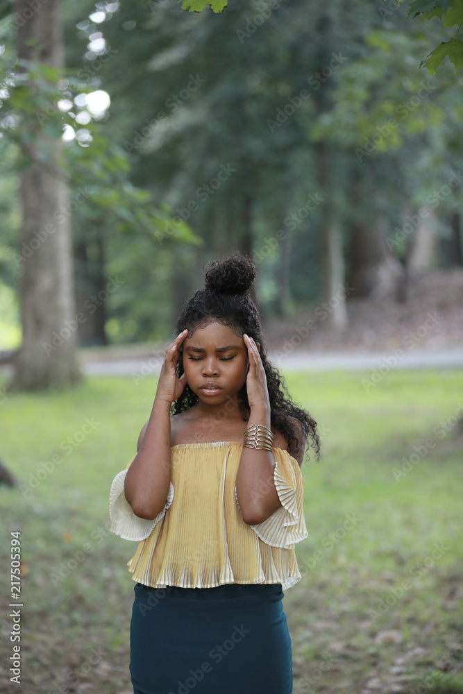 Thoughtful ethnic woman standing in woods with eyes closed Thoughtful ethnic woman standing in woods with eyes closed