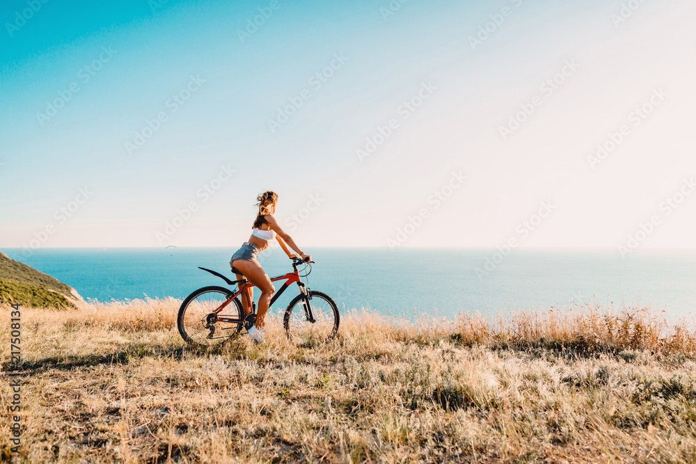 Fototapeta premium Young pretty woman with mountain bicycle in outdoor