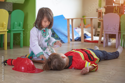 Φωτογραφία little girl and boy are pretending in nurse help treat ladderman meet accident i