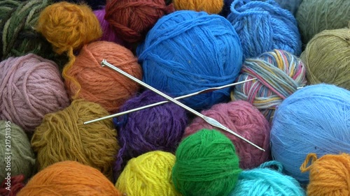Rotating many  yarn wool balls with two metal knitting crotchets