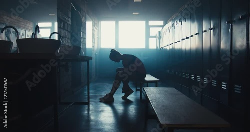 DOLLY IN Caucasian female athlete preparing for a workout in a gym locker room, tying shoelaces before training session. 4K UHD 60 FPS SLOW MOTION photo