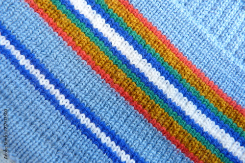 knitted fabric close-up soft fabric stripes natural material background for decoration blue red white yellow color geometric pattern lines crochets scarf clothes wool