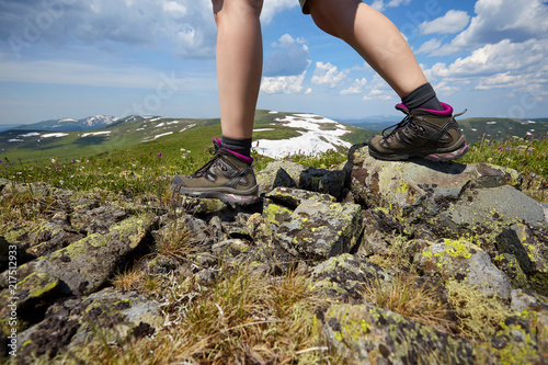 Hiker in the mountains. Photo of legs in trekking boots.
