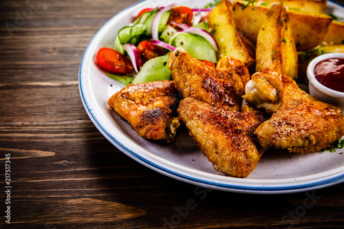 Roast chicken wings, chips and vegetables