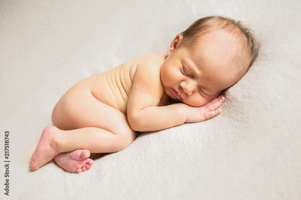 Naked newborn baby sleeping on a light background. Copy space Naked newborn baby sleeping on a light background. Copy space