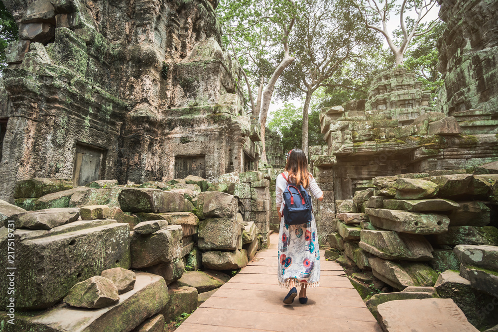 Fototapeta premium Młoda podróżniczka odwiedzająca świątynię ta prohm w kompleksie Angkor Wat, dziedzictwo architektury khmerskiej w Siem Reap w Kambodży