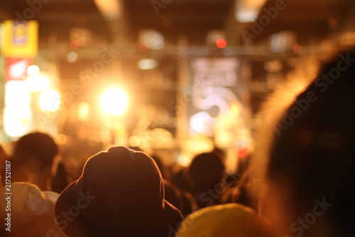 Concert spectators in front of a bright stage with live music