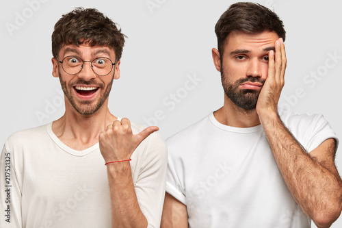 Positive Caucasian young male with dark hair, points with thumb at his discon...