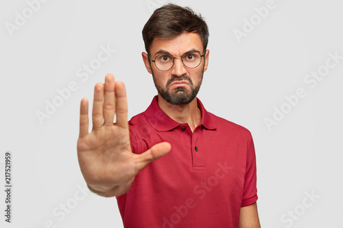 Foto It`s forbidden! Angry displeased young male frowns face, shows stop gesture, kee